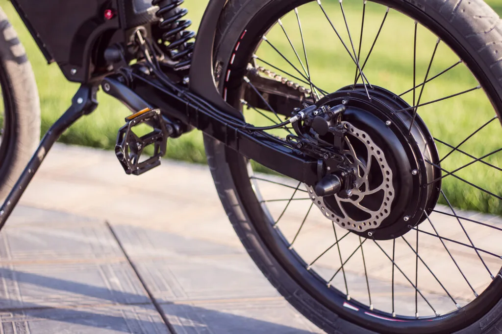 Electric bike motor wheel close up with pedal and rear shock absorber